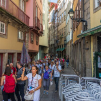 Tourists follow their leader on a street next to the Porto riverfront.
