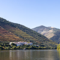 A grand wine estate along the Rio Douro, with terraced vineyards on the hills.